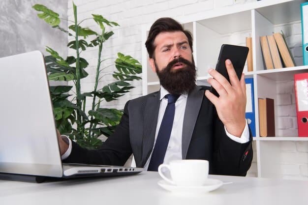 A hand holding a phone while talking to a creditor, with a focused and determined expression. The background is a home office setting.