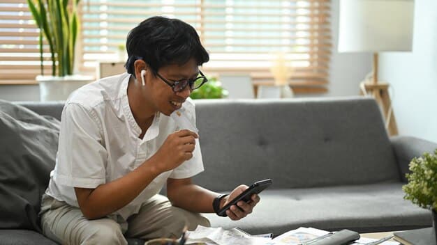 A young Filipino professional is using a budgeting app on her smartphone while sitting at a coffee shop. She appears focused and in control of her finances, highlighting the importance of technology in managing personal debt.