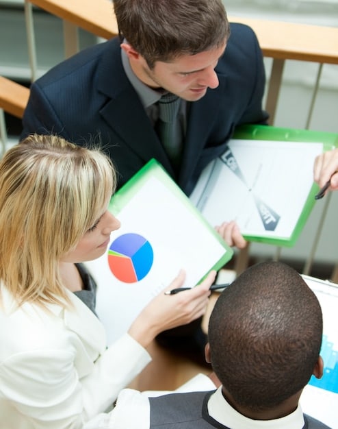 A person seeking advice from a financial advisor, with charts and graphs in the background.